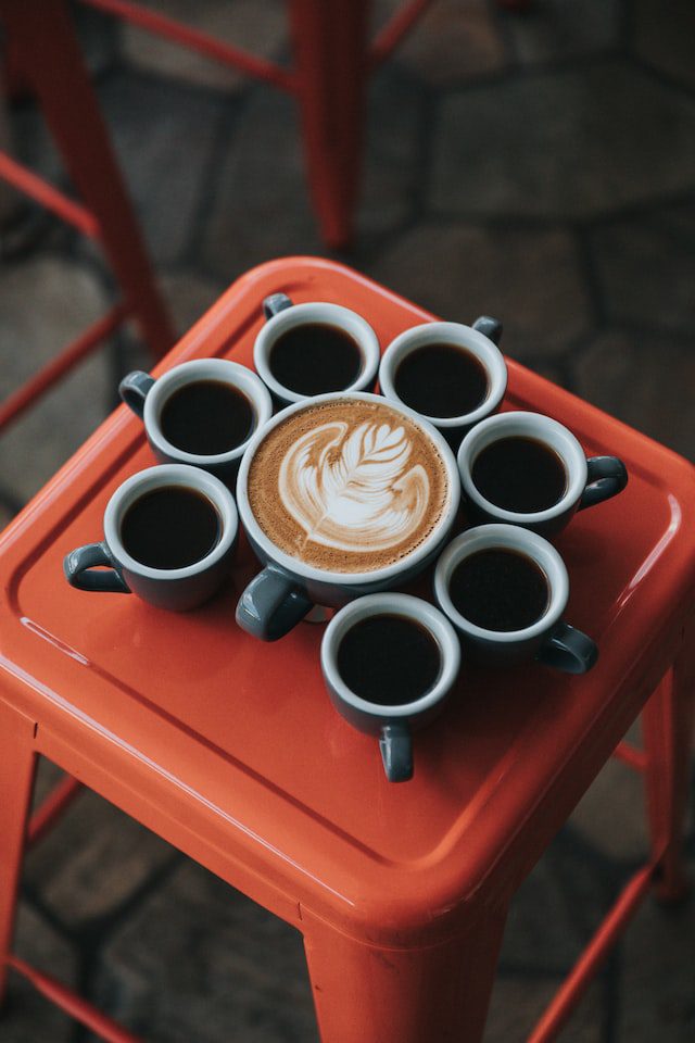 Cups of coffee on a red stool